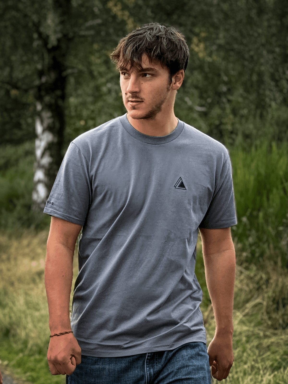 Man wearing the Stravaig Mens Everyday Trail T-Shirt in Haar Grey in a woodland setting