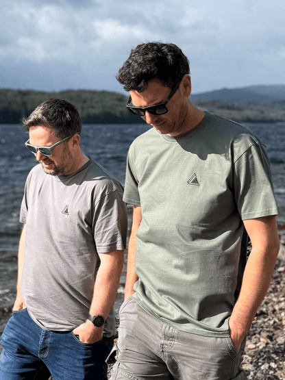 Two men walking along a loch shore in Stravaig Everyday Trail T-Shirts in Highland Moss and grey
