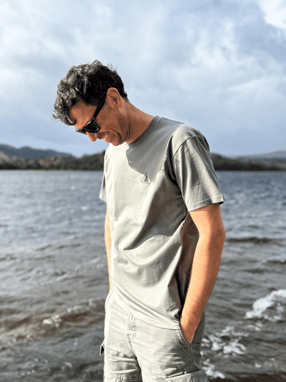 Man looking down at the loch shore wearing the Stravaig Mens Everyday Trail T-Shirt in Highland Moss