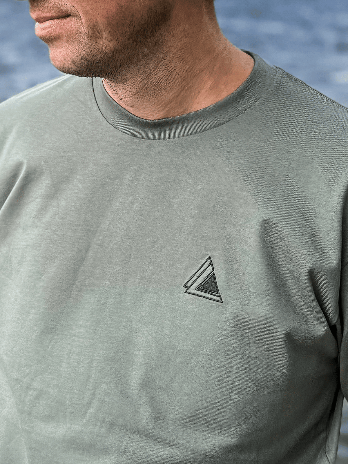 Close-up of the embroidered Stravaig logo on the chest of the Mens Everyday Trail T-Shirt in Highland Moss