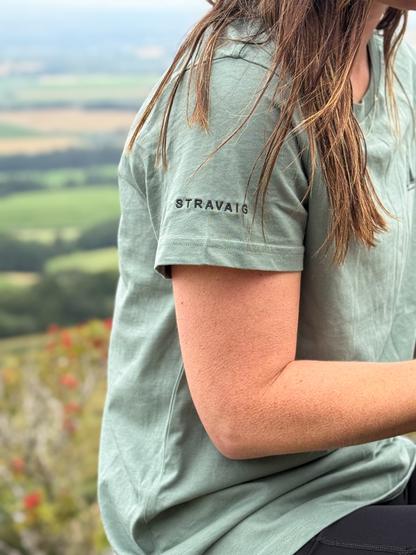 Close-up of the Stravaig sleeve print on the Machair Sage womens t-shirt with countryside views behind