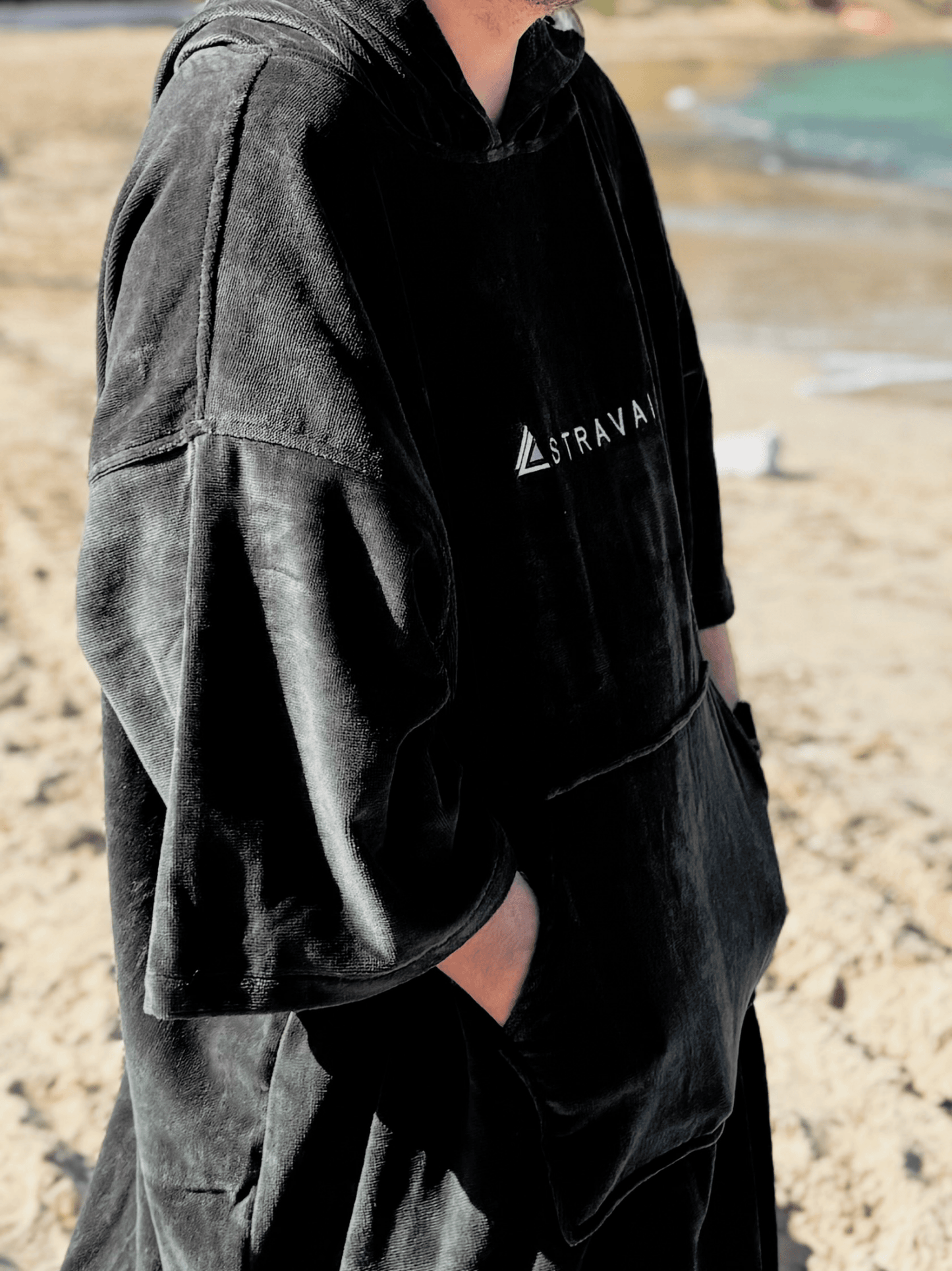 Person wearing a Sgàil Grey changing robe towel outdoors on the beach