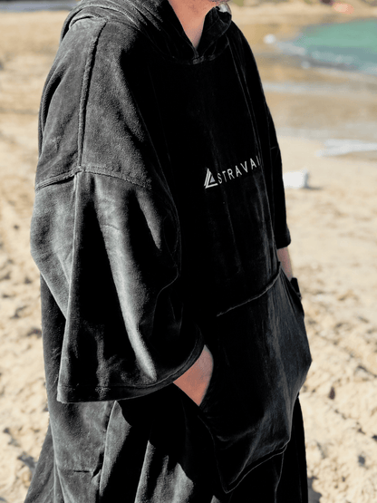 Person wearing a Sgàil Grey changing robe towel outdoors on the beach